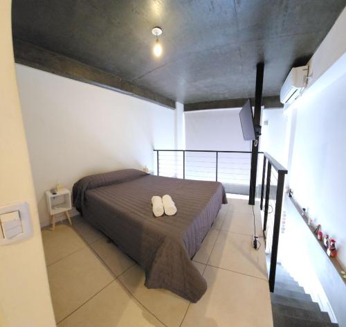 圣米格尔·德·图库玛Casita de Tucumán - Loft San Martin的一间卧室,床上有两双白鞋