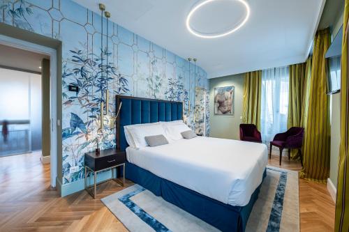 佛罗伦萨Glimpse Hotel的一间卧室设有一张大床和蓝色的墙壁