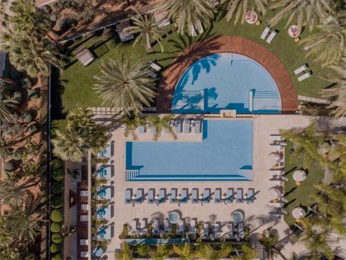 圣埃乌拉利亚Aguas de Ibiza Grand Luxe Hotel - Small Luxury Hotel of the World的享有带游泳池的度假村的顶部景致