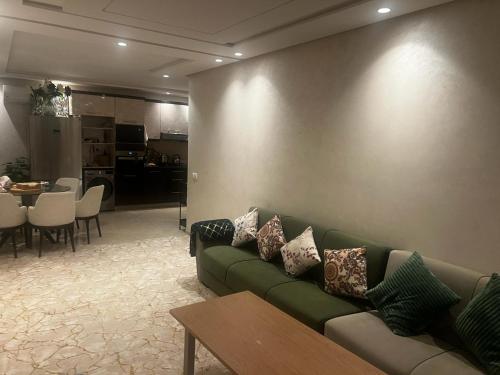 卡萨布兰卡App Alya Casablanca的客厅配有绿色沙发和桌子