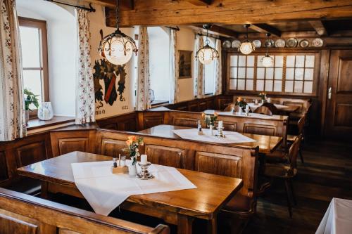 Mauern尊艾腾沃特酒店的餐厅设有木桌、椅子和吊灯。