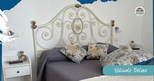 普拉Residenza del Barone Luxury House - Pula, Sardegna的一间卧室配有一张带白色床头板和枕头的床。
