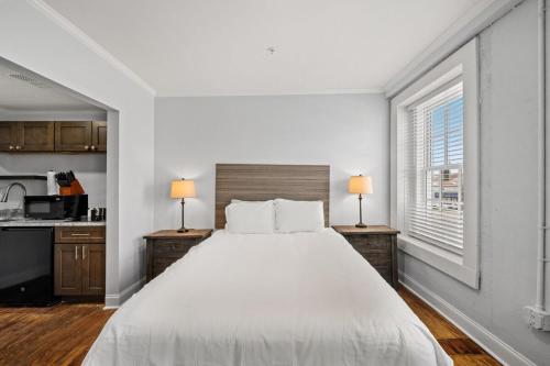 康威Modern Retreat in the Heart of Conway的白色卧室配有一张大床和两盏灯。