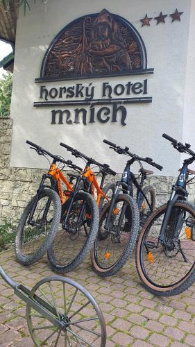 波布洛维克Horsky Hotel Mnich的停在酒店标志前的一组自行车