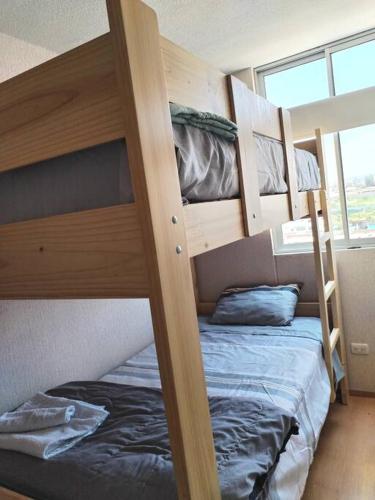 塔克纳Bello departamento en altozano的带窗户的客房内的两张双层床
