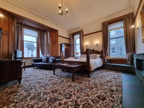 凯西克凯瑟克公园酒店的一间卧室配有一张床、一张沙发和窗户。