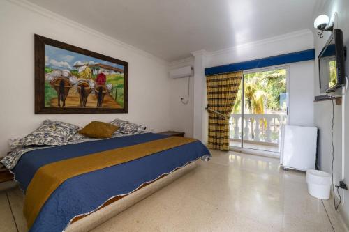 圣赫罗尼莫Hotel Posada San Sebastian的卧室配有一张床,墙上挂有绘画作品