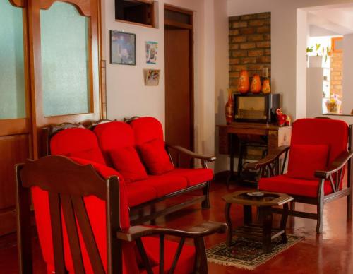 CarazYoly's House的客厅配有红色椅子和红色沙发