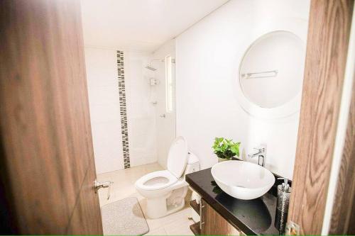 约帕尔Espectacular apartamento en excelente sector的一间带卫生间、水槽和镜子的浴室