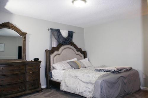 约翰逊城MD Cozy Corner的一间卧室配有一张床、梳妆台和镜子