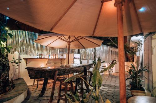 Stone TownPili Pili Kahawa House的一间带桌子和两把大遮阳伞的餐厅
