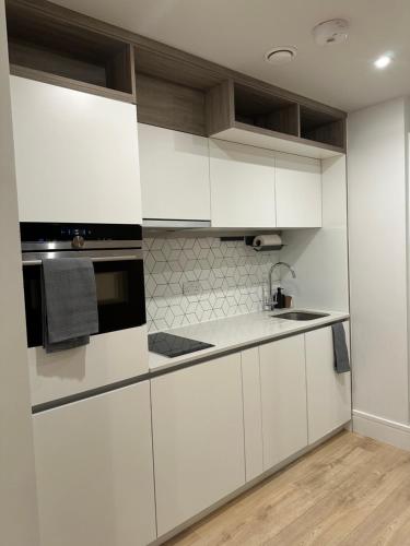 伦敦Luxury Capella Court的厨房配有白色橱柜和黑微波炉
