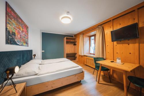 基茨比厄尔Gästehaus Johanna的一间卧室配有一张床、一张书桌和一台电视
