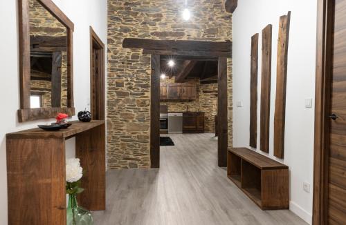 卢戈Casa Rural Lar de Sanxes的开放式走廊设有石墙和木地板