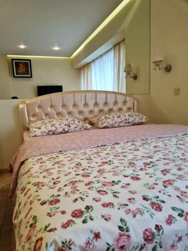 第聂伯罗基洛夫公寓酒店的一间卧室配有一张带花卉床罩的大床