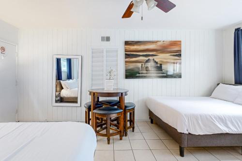 纽波特海滩Balboa Beauty III的一间卧室配有两张床、一张桌子和一把椅子
