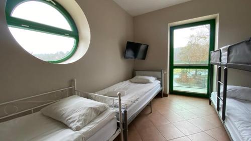 姆拉哥沃Pokoje na Cyplu的配有镜子和窗户的客房内的两张床