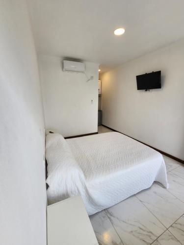 帕特拉德拉帕特拉SONSOLES HOTEL的卧室配有白色的床和墙上的电视。