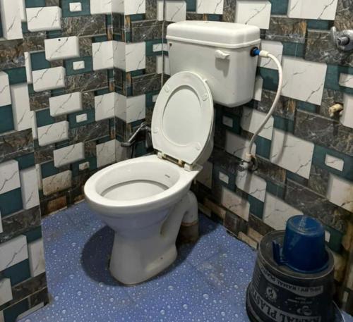 德奥加尔GRG Sunrise Plaza Deoghar的浴室设有卫生间和瓷砖墙