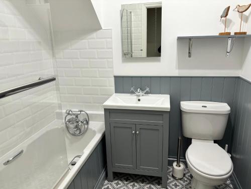 洛斯特威希尔Little Oaklands的浴室配有卫生间、盥洗盆和浴缸。