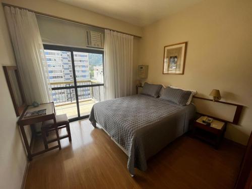 里约热内卢克拉里奇MC住宅酒店的一间卧室设有一张床和一个大窗户