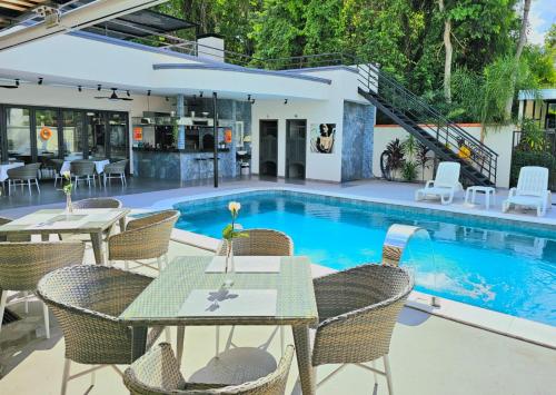 圣贝纳迪诺Hotel Oasis-Dream Holidays - La Petite France的房屋前设有带桌椅的游泳池