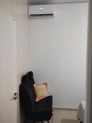 Genuino SampaioQuarto confortável em Est Velha的客房内的一张带枕头的黑椅子