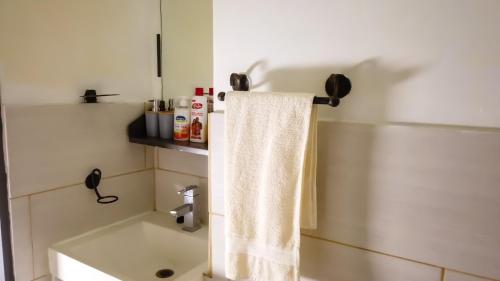 约翰内斯堡Tranquil Living on Maboneng的浴室设有挂在架子上的白色毛巾