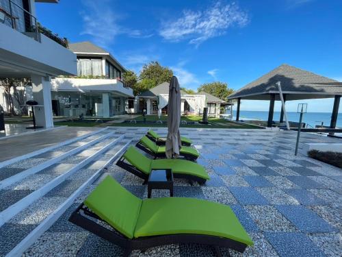 苏梅岛Bluemango Pool Villa & Resort Koh Samui的一排绿色躺椅和一把遮阳伞