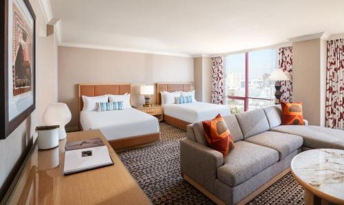 拉斯维加斯Rio Hotel & Casino的酒店客房,设有两张床和一张沙发