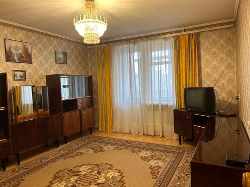 苏梅Недорога квартира на Харківській, 32的一间带电视和吊灯的客厅