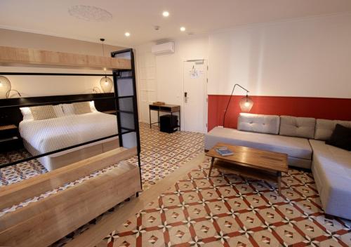 瓦伦西亚VALOLA Boutique Rooms的酒店客房,配有床和沙发