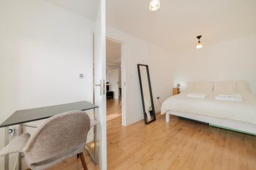 伦敦Brand new one bedroom flat in Central London的一间卧室配有一张床、一张书桌和一面镜子