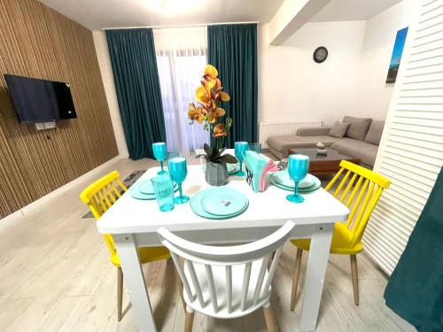 普洛耶什蒂Residence 3的客厅配有白色桌子和黄色椅子