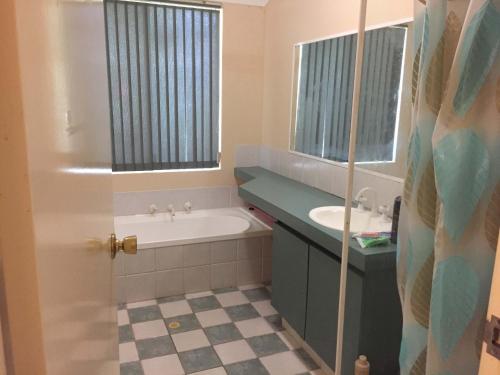 珀斯double room share bathroom and kitchen的带浴缸和盥洗盆的浴室