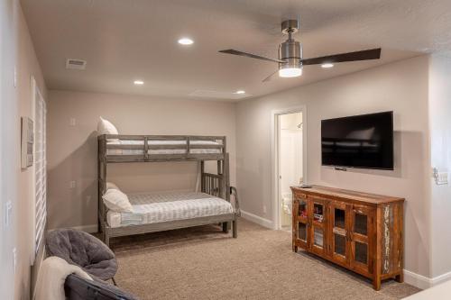 圣乔治Red Cliff Farmhouse的一间卧室配有双层床和一台平面电视。