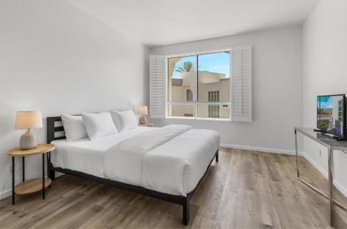 棕榈泉Modern & Uncluttered - A Ryson Property的白色的卧室设有一张大床和一个窗户