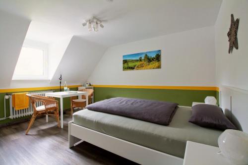 施莱登Toms Gästehaus的一间卧室配有一张床、一张桌子和一张桌子