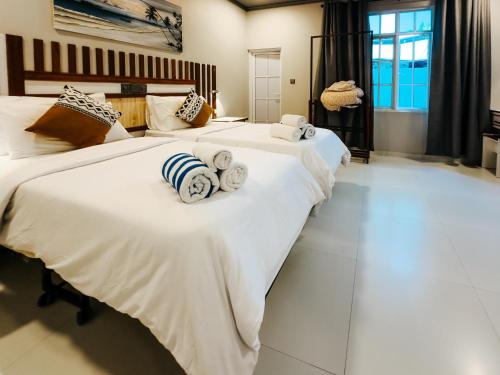 KamadhooHoliday home in Kamadhoo Island / Maldives的卧室内的两张床,配有白色的床单和毛巾