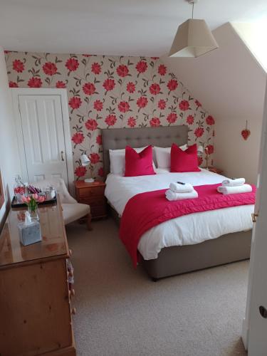 因弗内斯斯姆旅舍的一间卧室配有一张带红色枕头的大床