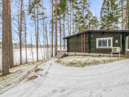 NummiHoliday Home Villa lahnajärvi by Interhome的雪中树林里的一个小房子