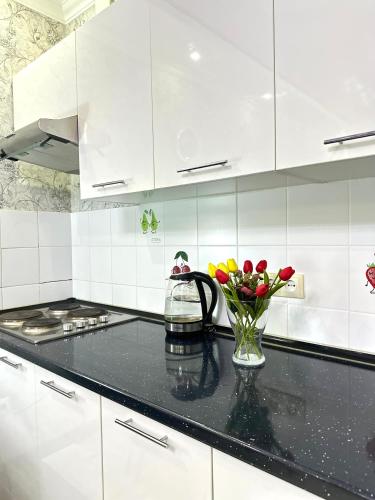 阿克套ЖК Тыныштык的厨房配有白色橱柜和花瓶