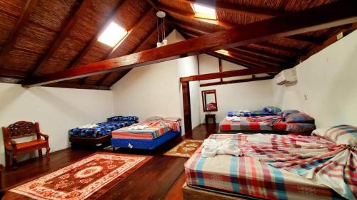 格拉纳达Hotel Camaleon Granada的带3张床的客房,拥有木制天花板