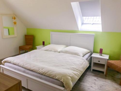 WustrowUrlaub am Plätlinsee Haus Leonore的卧室设有一张白色大床和绿色的墙壁