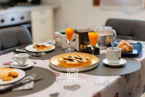 圣萨尔沃LIBERA HOUSE - Sweet Apartments的餐桌上放有食物和橙汁
