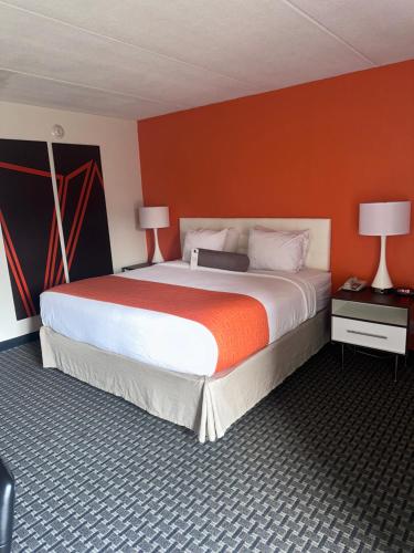 纽堡纽堡豪生酒店的一间卧室配有一张带橙色墙壁的大床