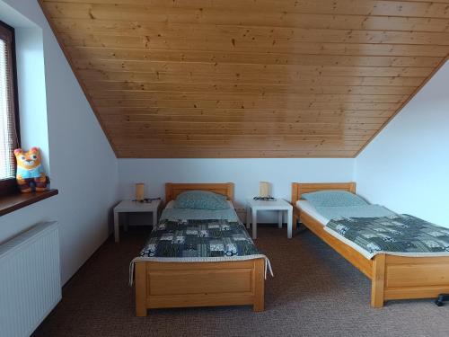 VavrišovoTatry TOP Dom的配有木天花板的客房内的两张床