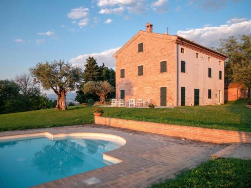 TreiaAgriturismo Bibiano38的一座古老的建筑和一个位于大楼前的游泳池