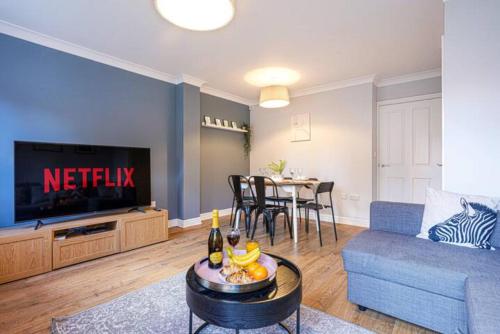 米尔顿凯恩斯Forthill House - Close to City Centre - Free Parking, Super-Fast Wifi and Smart TV with Netflix by Yoko Property的客厅配有蓝色的沙发和电视