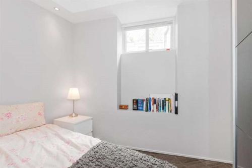 卑尔根佩佩斯公寓的白色的卧室设有床和窗户